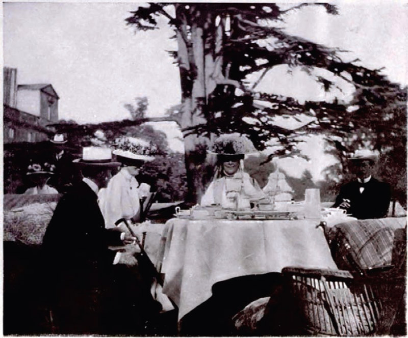 Figura 1: Wilton tea-party: Lord and Lady Lansdowne, Lady de Grey and Lord Pombroke, fotografía extraída del libro Queen Alexandra’s Christmas gift book: photographs from my camera to be sold for charity (1908) donde se representa la moda del momento el servicio del té al aire libre disfrutando del paisaje