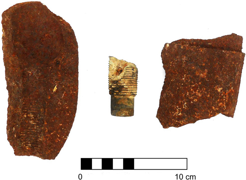 Figura 7. Fragmentos de granada de metralla de 75 mm de los cañones Saint Chamond-Mondragón. A los costados: segmentos del cuerpo del proyectil y al centro: parte de la espoleta.